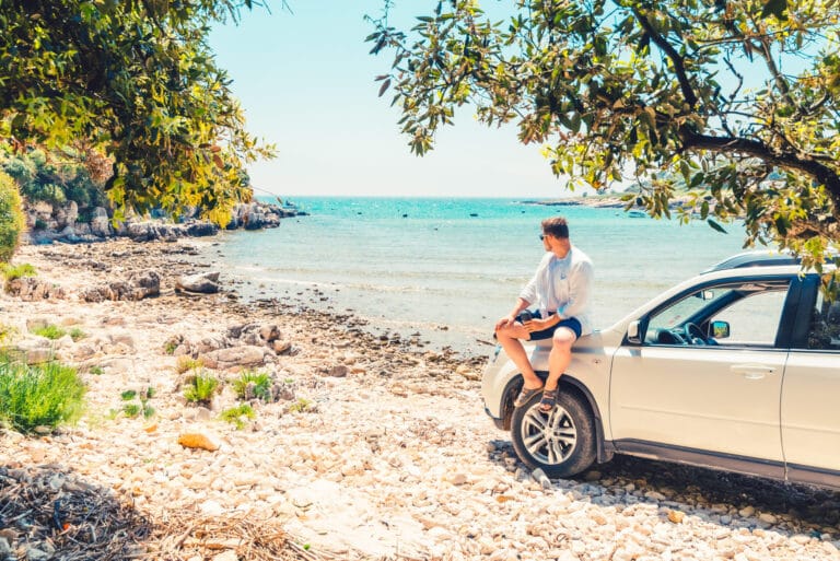 Automax Corfu Car Rental man siting on a car